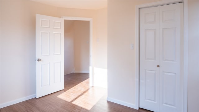 unfurnished bedroom with a closet and hardwood / wood-style floors