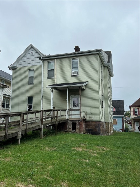 rear view of property with a wooden deck, a yard, and cooling unit