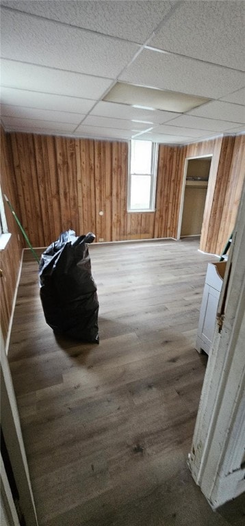 interior space featuring a paneled ceiling and hardwood / wood-style floors