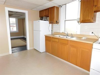 kitchen featuring a paneled ceiling, sink, stove, and white refrigerator