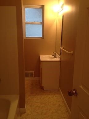 bathroom featuring vanity and a tub to relax in