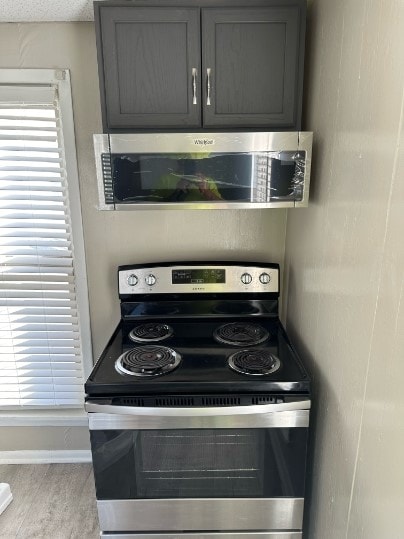 kitchen featuring gray cabinets, light hardwood / wood-style floors, a textured ceiling, and appliances with stainless steel finishes