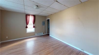 unfurnished room with a drop ceiling and light hardwood / wood-style flooring