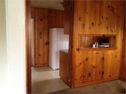 kitchen with wood walls and white refrigerator