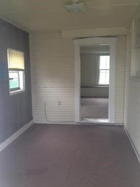 unfurnished room with wood walls