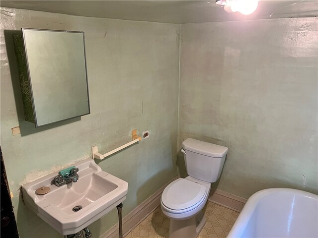 bathroom with sink, a tub, and toilet