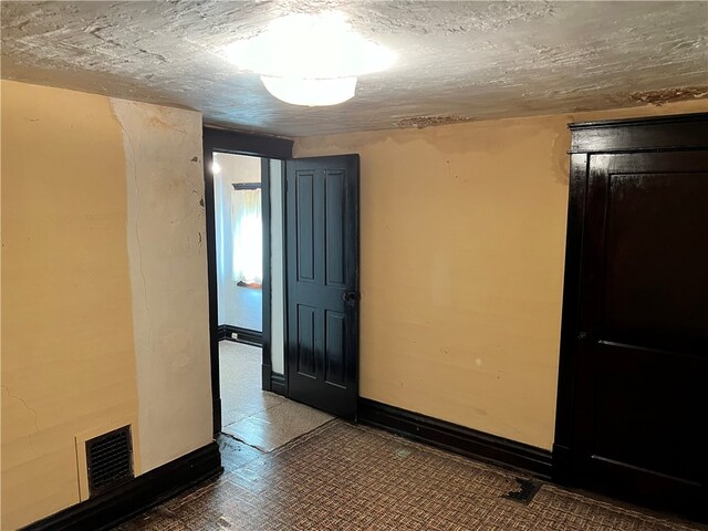 unfurnished room featuring a textured ceiling