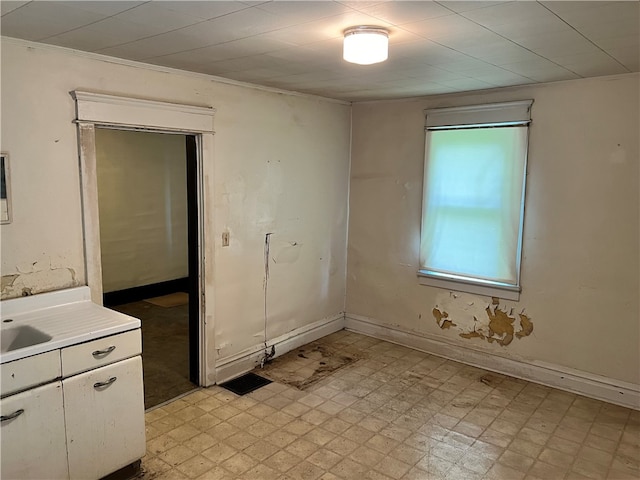 empty room featuring sink and ornamental molding