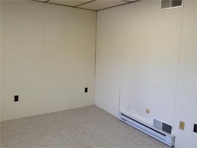 carpeted empty room with a baseboard radiator