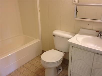 bathroom featuring tile patterned floors, vanity, and toilet