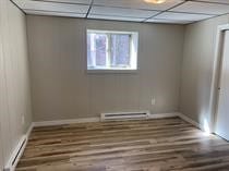 unfurnished room with a drop ceiling, baseboard heating, and dark wood-type flooring