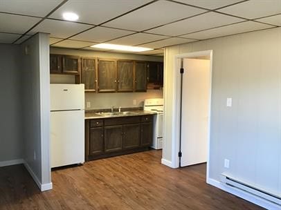 kitchen with stove, sink, a baseboard radiator, white fridge, and dark hardwood / wood-style flooring