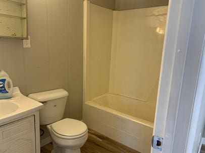 full bathroom with shower / tub combination, vanity, wood-type flooring, and toilet