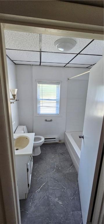 bathroom with vanity, toilet, a drop ceiling, and a baseboard radiator