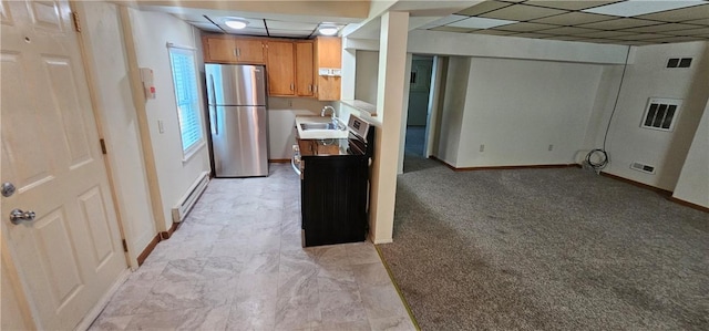 kitchen featuring stainless steel fridge, baseboard heating, sink, and light carpet