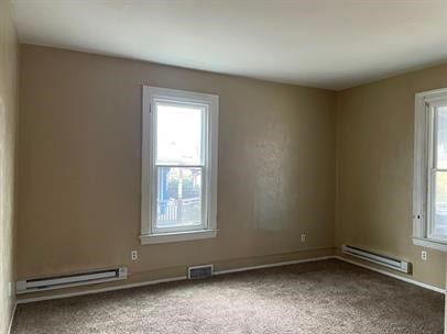 unfurnished room featuring carpet and baseboard heating