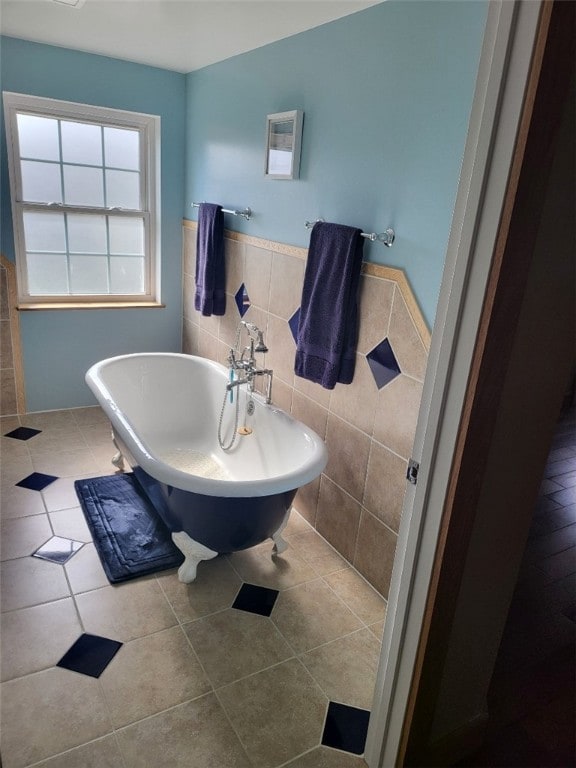 bathroom with tile patterned floors, a tub, and tile walls