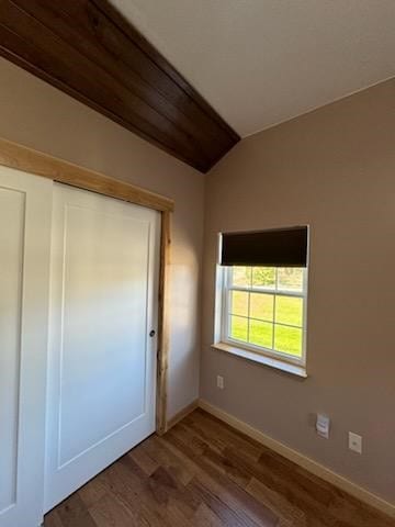 unfurnished bedroom with hardwood / wood-style floors, a closet, and vaulted ceiling