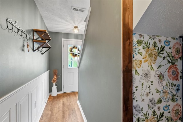 entryway featuring a textured ceiling and light hardwood / wood-style floors