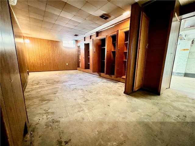 basement featuring wooden walls