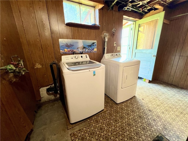 washroom featuring wood walls and washer and dryer