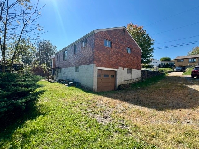 view of side of home with a lawn and a garage