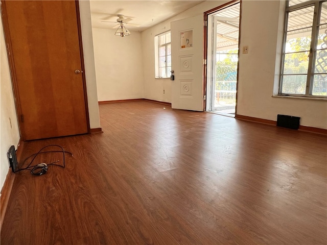 spare room with a wealth of natural light, ceiling fan, and hardwood / wood-style flooring