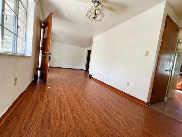 spare room featuring vaulted ceiling, dark hardwood / wood-style floors, and ceiling fan