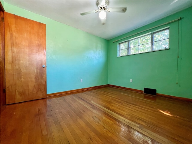 spare room featuring wood-type flooring and ceiling fan