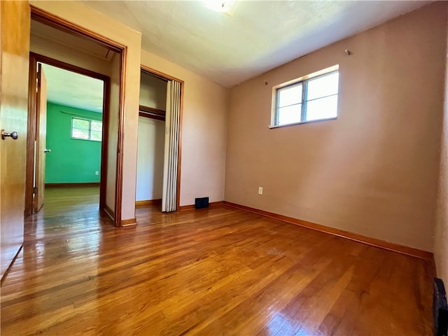 unfurnished bedroom with wood-type flooring and a closet