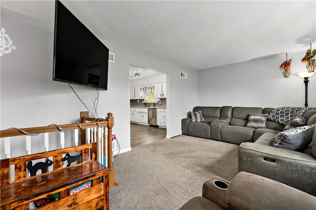 living room featuring a textured ceiling and dark carpet