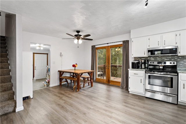 kitchen featuring ceiling fan, white cabinets, light hardwood / wood-style flooring, backsplash, and appliances with stainless steel finishes