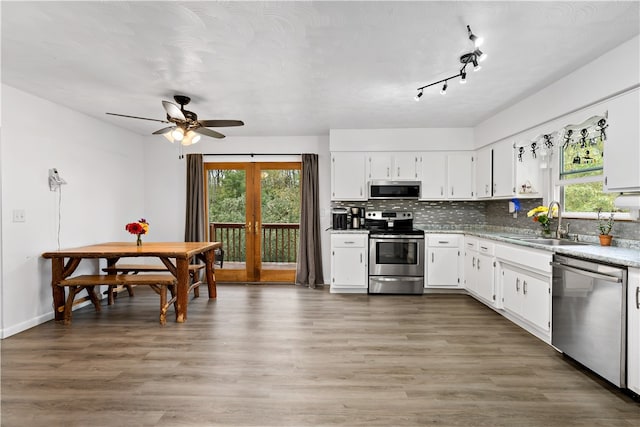 kitchen with white cabinets, dark hardwood / wood-style flooring, stainless steel appliances, french doors, and sink