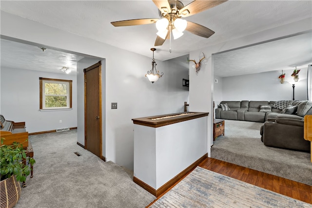 living room featuring wood-type flooring, a textured ceiling, and ceiling fan