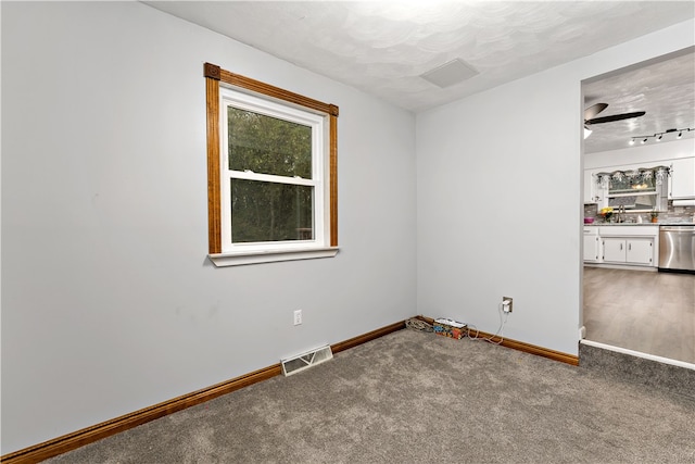 carpeted empty room featuring ceiling fan and sink