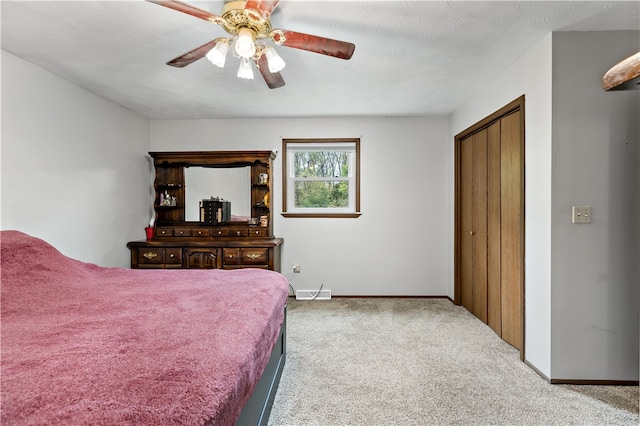 carpeted bedroom featuring ceiling fan and a closet