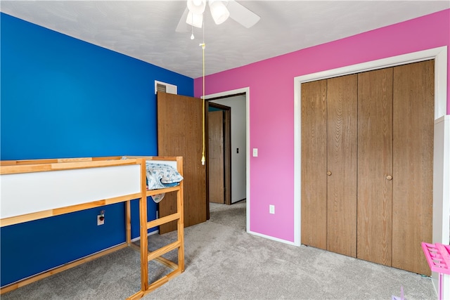 unfurnished bedroom with ceiling fan, light colored carpet, and a closet