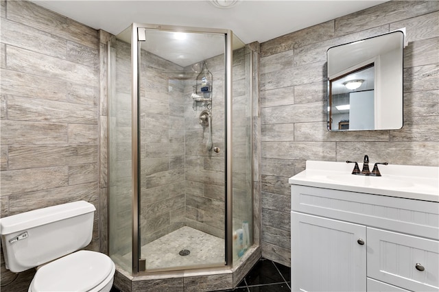 bathroom with tile walls, walk in shower, vanity, and toilet