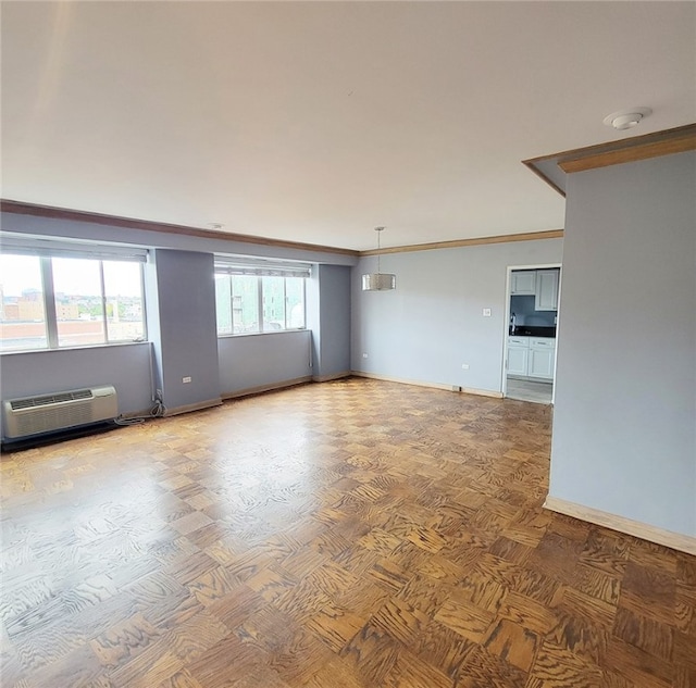 unfurnished living room featuring crown molding and a wall mounted AC