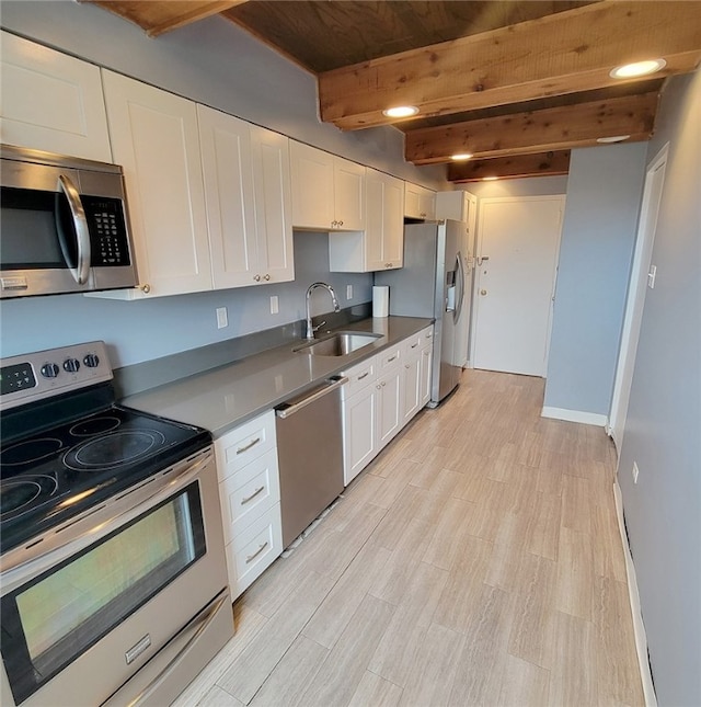 kitchen with light hardwood / wood-style floors, beamed ceiling, sink, white cabinets, and stainless steel appliances