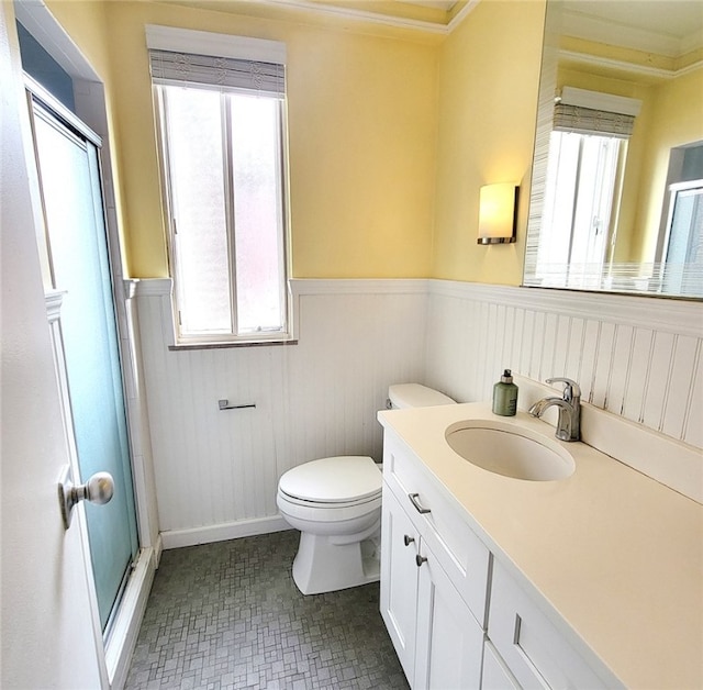 bathroom with walk in shower, vanity, crown molding, and toilet