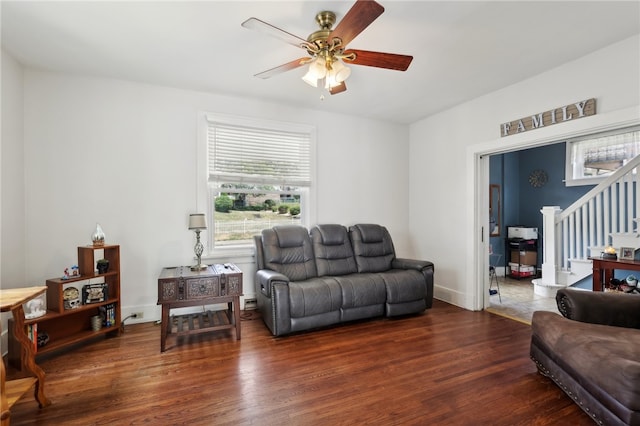 living room with ceiling fan and dark wood-type flooring