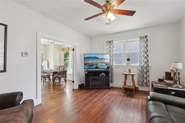 living room featuring ceiling fan and dark hardwood / wood-style floors