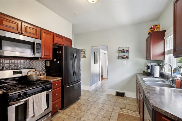 kitchen featuring backsplash, appliances with stainless steel finishes, light tile patterned flooring, and sink