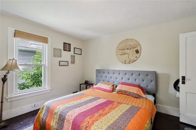 bedroom with dark hardwood / wood-style flooring