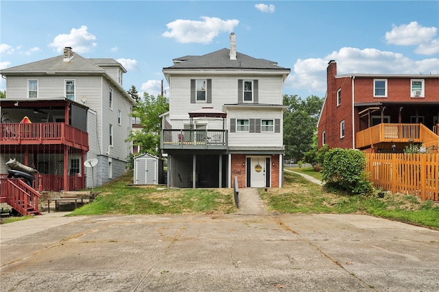 rear view of house featuring a balcony and a garage