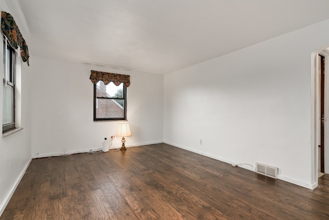 unfurnished room with dark hardwood / wood-style flooring