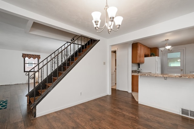 kitchen featuring light stone countertops, dark wood-type flooring, pendant lighting, and white refrigerator