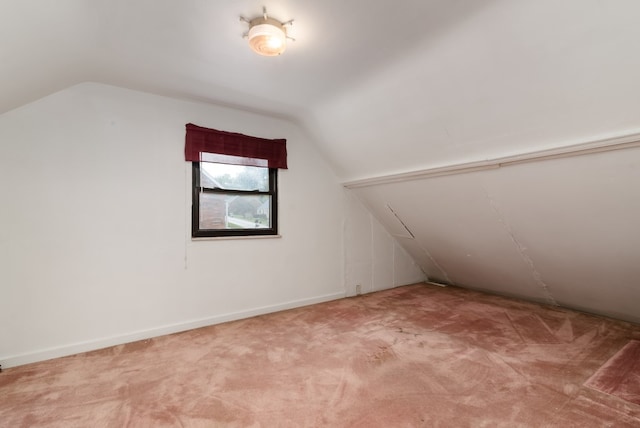 bonus room with lofted ceiling and light colored carpet