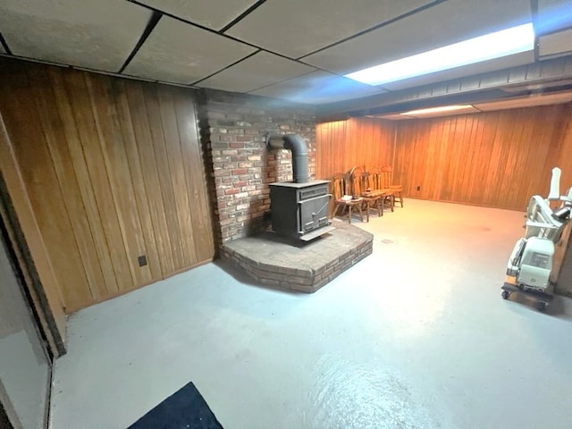 basement with a wood stove and wood walls